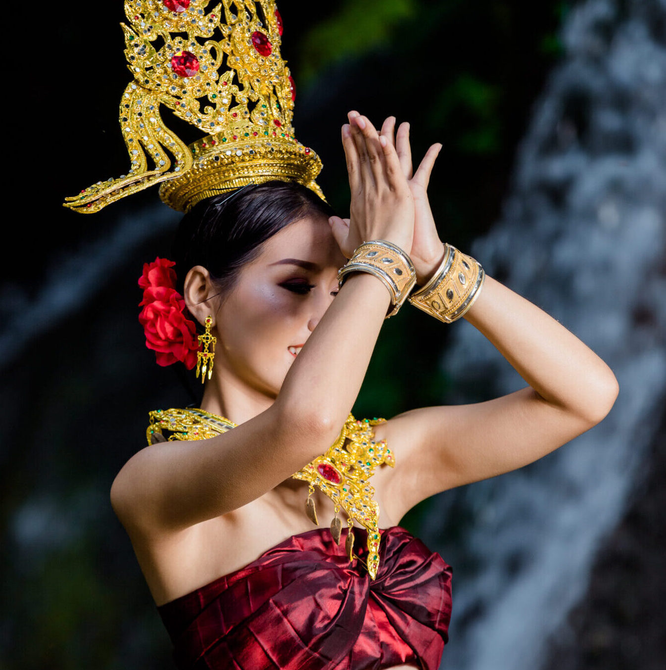 A woman dressed with an ancient Thai dress at the waterfall.